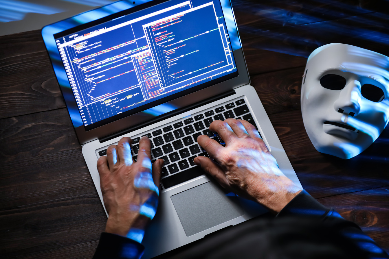 Hands of Hacker with Laptop on Dark Background